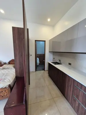 a kitchen with a sink and a bed in a room at Prabhu Villla Upper Deck in Perumbavoor