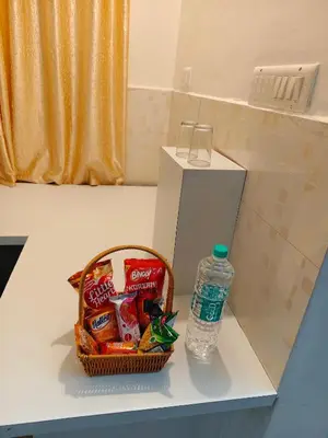 a basket of chips and a bottle of water on a counter at Sree manjulal Inn in Guruvāyūr