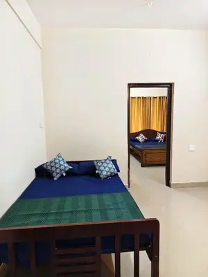 a bedroom with a bed and a mirror at Sree manjulal Inn in Guruvāyūr
