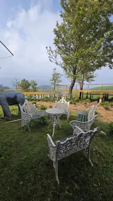 a group of chairs and a table in a field at Silver lake nature escape in Ooty