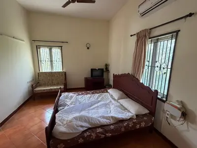 a bedroom with a bed in a room with windows at Didan Stays in Coimbatore
