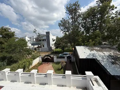 a white fence in front of a house at Didan Stays in Coimbatore
