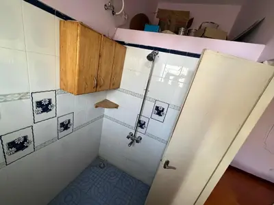 a bathroom with a shower with white tiles at Didan Stays in Coimbatore