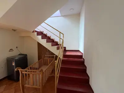a staircase in a house with red carpeted stairs at Didan Stays in Coimbatore