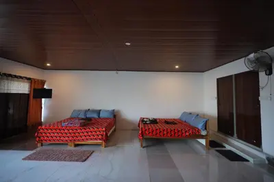 a living room with two beds and a couch at Coorg Backwaters in Suntikoppa