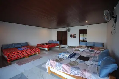 a room with two beds and a couch at Coorg Backwaters in Suntikoppa