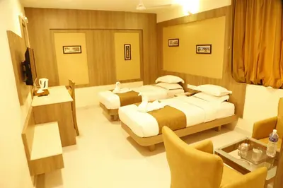 a hotel room with two beds and a table at HOTEL GRAND PLAZzA in Coimbatore