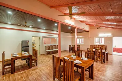 a dining room with wooden tables and chairs at Alaya Stays APR Pet-Friendly One-Room Suites with Swimming Pool in Bengaluru, Karnataka