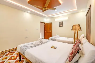 a bedroom with two beds and a ceiling fan at Alaya Stays APR Pet-Friendly One-Room Suites with Swimming Pool in Bengaluru, Karnataka