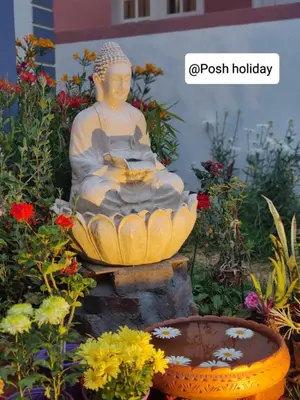 a statue of a buddha sitting in a garden at Posh Holidays in Ooty