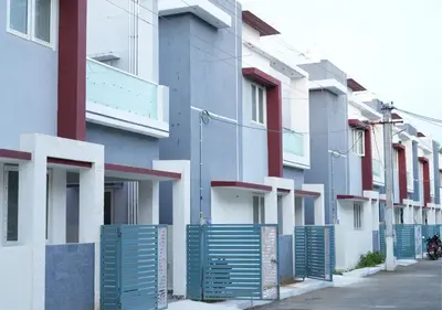 a row of buildings with blue gates on a street at Village Homestays By Adrta Groups in Marudhamalai