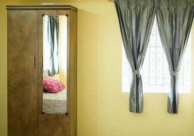 a mirror in a room with a window at Village Homestays By Adrta Groups in Marudhamalai