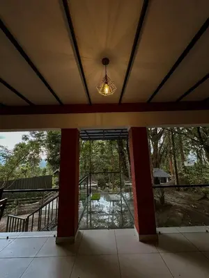 an empty house with a large glass door and a light at Rockviewstay in Kalpetta