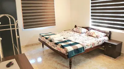 a bedroom with a bed with two pillows and a window at White Haven in Angamali