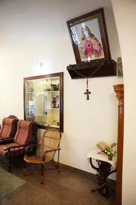 a room with a chair and a cross on the wall at White Haven in Angamali
