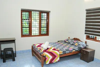 a bedroom with a bed and a table and a fireplace at White Haven in Angamali