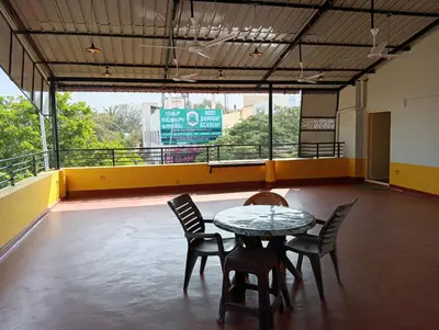 a table and chairs in a room with a balcony at MANTRAs in Mysore