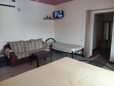 a living room with a couch and a bed at MANTRAs in Mysore