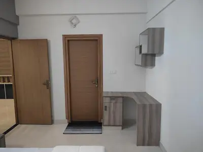 a hallway with two wooden doors and a staircase at Aapt green field in Trichūr