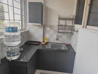 a kitchen with a sink and a counter with water bottles at Aapt green field in Trichūr