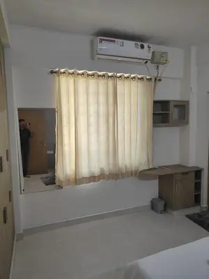 a man taking a picture of a room with a curtain at Aapt green field in Trichūr