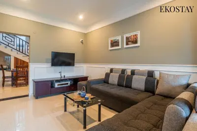 a living room with a couch and a tv at EKOSTAY - Helios Villa in Kodaikānāl