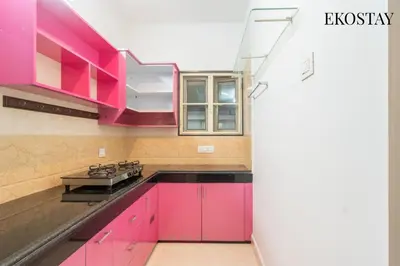 a kitchen with pink cabinets and a stove at EKOSTAY - Helios Villa in Kodaikānāl