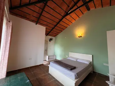 a bedroom with a bed with a wooden ceiling at Paddy Creek Jungle Resort Coorg in Virajpet