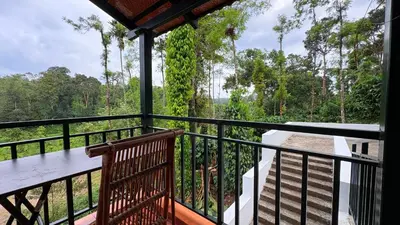 a balcony with a view of the forest at Paddy Creek Jungle Resort Coorg in Virajpet
