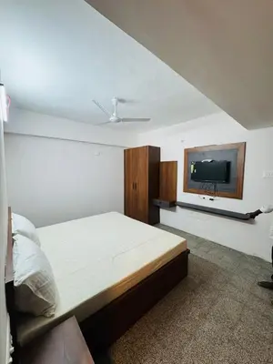 a bedroom with a bed and a flat screen tv at hotel sri kaliappaa in Coimbatore