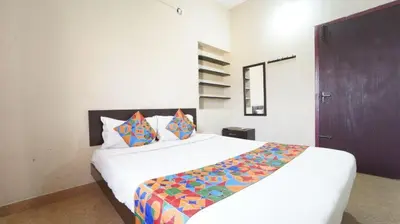 a bedroom with a large white bed with colorful pillows at H N Residency in Coimbatore