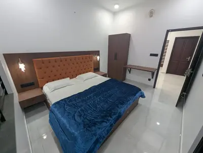 a bedroom with a large bed with a blue blanket at Nana's Residency in Ernakulam