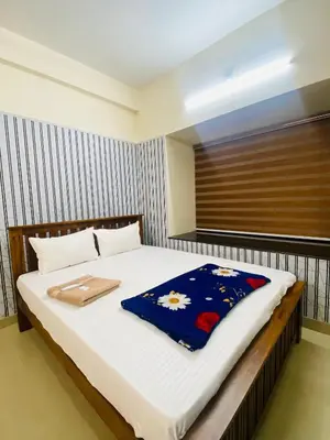 a bedroom with a bed with a blue blanket on it at Apartment in Guruvayur- Sooryamadhavam-only for families in Guruvāyūr