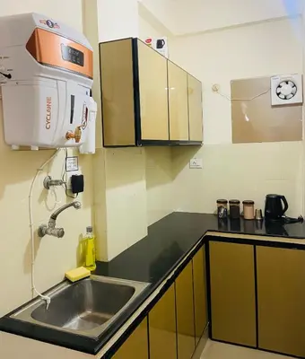 a kitchen with a sink and a coffee maker at Apartment in Guruvayur- Sooryamadhavam-only for families in Guruvāyūr