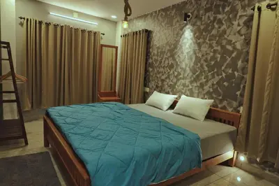 a bedroom with a bed and a stone wall at Vista Chembra Service Apartment 20B in Meppādi