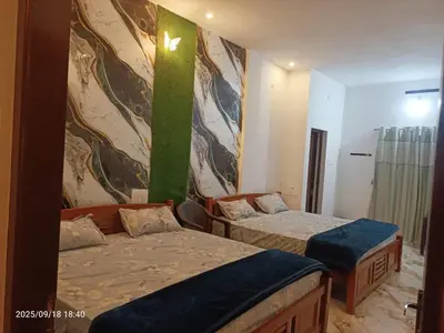 a bedroom with two beds and a green wall at Darby Homestay in Kanthalloor