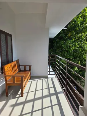 a wooden bench sitting on a balcony at Paithal haven in Paithalmala