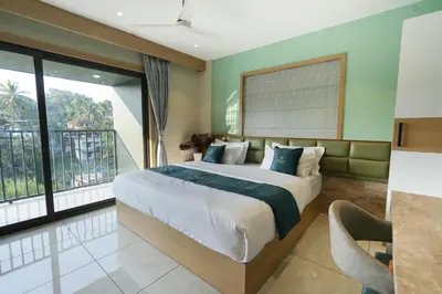 a bedroom with a large bed and a large window at Rasha Suites in Kalpetta