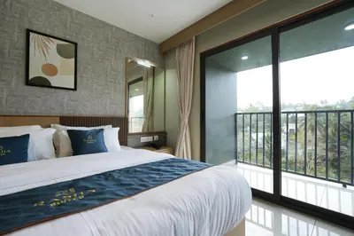 a bedroom with a large bed and a balcony at Rasha Suites in Kalpetta