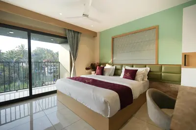 a bedroom with a large bed and a balcony at Rasha Suites in Kalpetta
