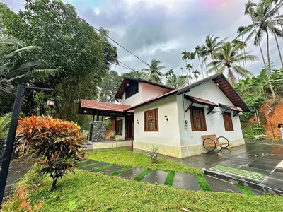 a small house in the middle of a garden at Bougainvilla in Kozhikode