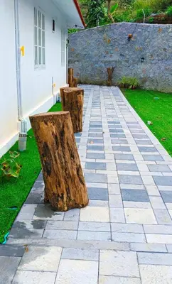 two wooden benches sitting on a patio with grass at White Cloud Stay Attappadi in Agali