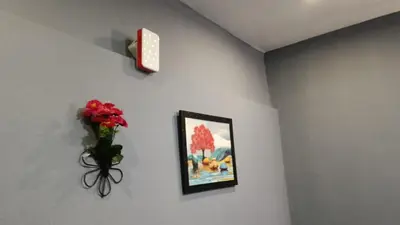 a vase of flowers on a wall with a picture at Msk indian Residency in Kodaikānāl