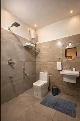 a bathroom with a toilet and a sink and a shower at Honeymoon holidays in Vythiri