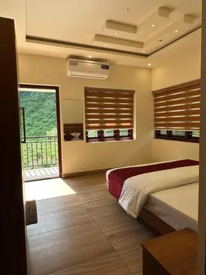 a bedroom with a bed and a large window at Honeymoon holidays in Vythiri