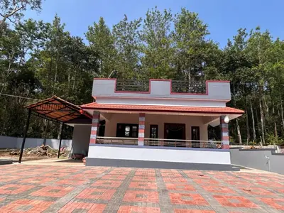 a small white building with a red roof at Aarvani Retreat Relax, Explore & Unwind in Coorg in Kushālnagar