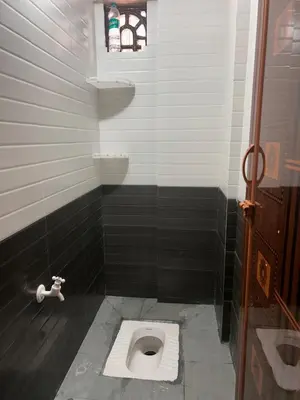 a bathroom with a toilet in a stall at Aarvani Retreat Relax, Explore & Unwind in Coorg in Kushālnagar