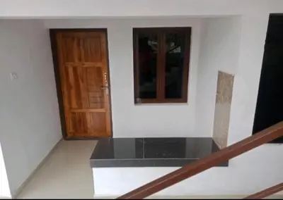 a room with a staircase and a wooden door at Aswathy Bhavan in Vadakkāncheri