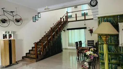 a living room with a staircase in a house at Parthipuram in Thottada