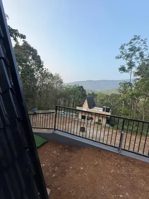 a view of a house from a balcony with a fence at Zerahs Private Pool Villa, Athirappilly - Extra upstair Bed space in Athirappally